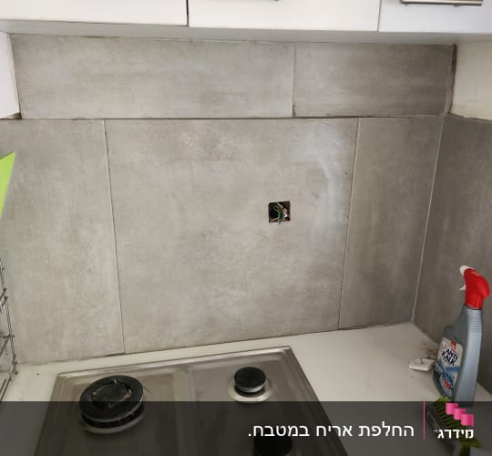 חיפוי קיר מטבח באריחי גרניט פורצלן אפורים מעל כיריים